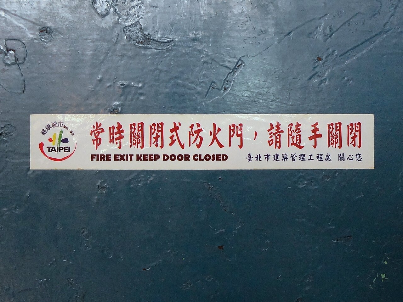 Puerta de salida con aviso de mantenerla cerrada